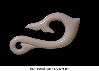 New Zealand Maori Handmade Carved Ox Bone Necklace Isolated On A Black Background.