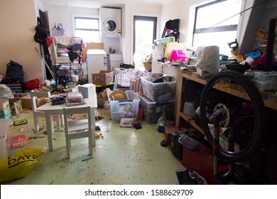 New Zealand - October 2 2019: Garage full of stuff, exercise equipment, clothes, junk. Looks like moving, decluttering, unpacking. Plastic tubs and boxes filled, empty. Typical scene spring cleaning