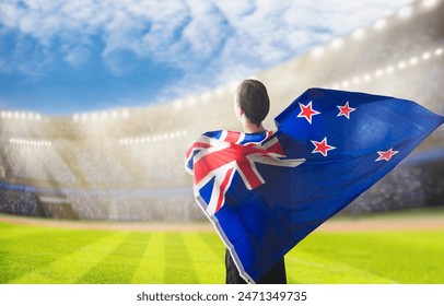 New Zealand supporter on stadium in cricket or rugby match. New Zealander fan on soccer pitch watching football team play. Supporters with flag and national jersey cheering in championship game. - Powered by Shutterstock