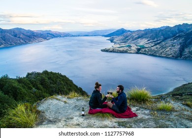 New Zealand, Wanaka Lake Travel Vacation. Happy Couple/friends Happy On The Mountain Top Hands Up With Wine Glasses, Enjoying Mountain, Lake Landscape Outdoor View. Freedom, Happiness Lifestyle