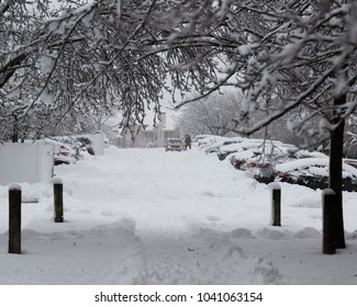 Newark, New Jersey - 03/07/2018 - New Jersey Winter Storm, Snow Covered Parking Lot With A Resident Trying To Shovel Snow For A Parking Spot