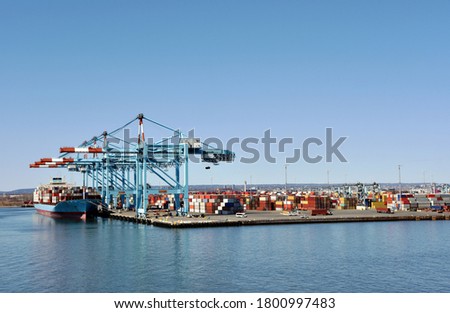 Newark, NJ / USA - View of the container terminal with berthed ship, gantry cranes are loading and discharging cargo from the vessel.	