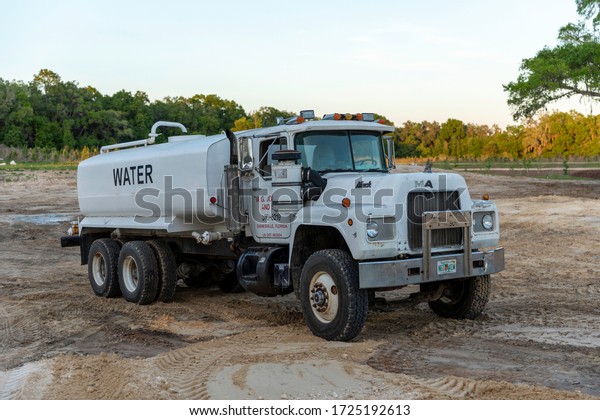 NEWBERRY, FLORIDA - April 6,\
2020: A road construction water truck parked in the Arbor Greens\
subdivision off Newberry Road where new housing construction will\
begin.