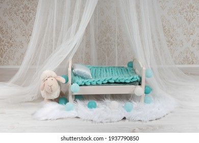 Newborn Baby Bed With A Little Sheep In A Photo Studio