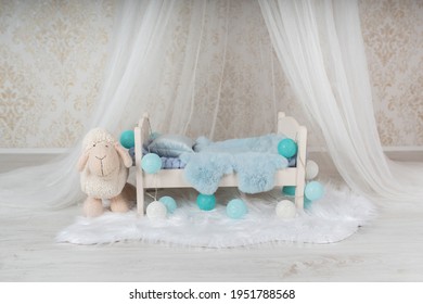 Newborn Baby Bed With A Little Sheep In A Photo Studio