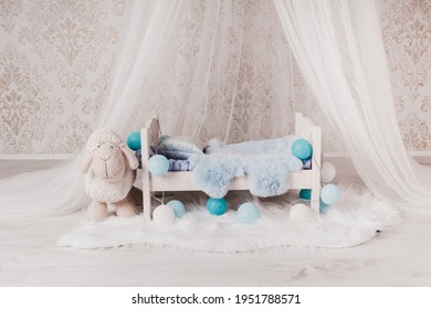 Newborn Baby Bed With A Little Sheep In A Photo Studio