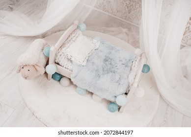 Newborn Baby Bed With A Little Sheep In A Photo Studio