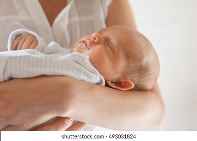 Newborn Baby Boy Asleep In Mother's Arms