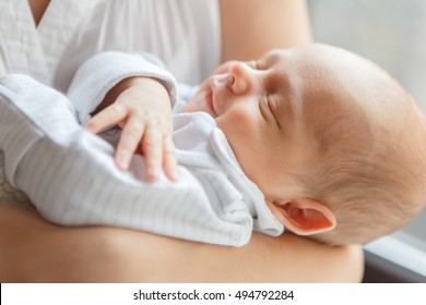 Newborn Baby Boy Asleep In Mother's Arms