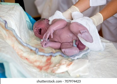 Newborn Baby Boy, First Seconds After Birth, Still Attached To The Umbilical Cord Stump Happiness Family Concept