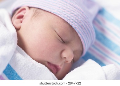 Newborn Baby Boy In Hospital Nursery Resting Peacefully