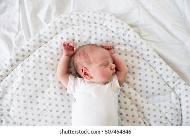 Newborn baby boy lying on bed, sleeping, close up