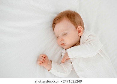 Newborn baby boy sleeping under a blanket in a white bodysuit on the bed with his hand folded under his cheek, sweet healthy baby sleep at home - Powered by Shutterstock