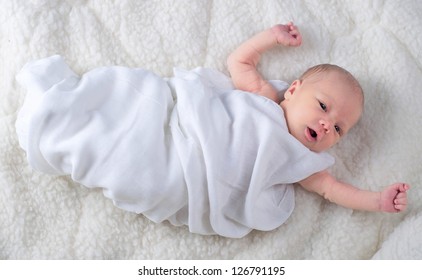 Newborn Baby Boy Wrapped In White Blanket