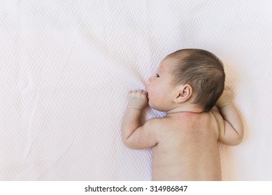 Newborn Baby Child Is Laying Down On The Floor