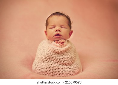 Newborn Baby in cocoon - horizontal portrait with open mouth