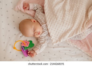 newborn baby covered with blanket sleeps in his crib with his favorite toy. healthy children's sleep without a pillow. happy carefree infancy. products for children, natural materials. space for text - Shutterstock ID 2144268191