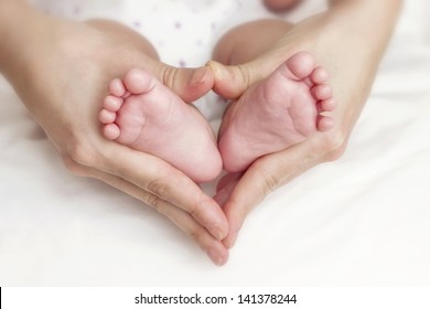 Newborn Baby Feet In The Mother Hands