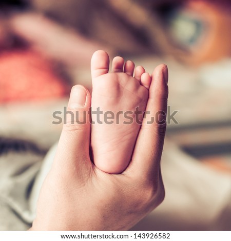 newborn baby feet on female hand
