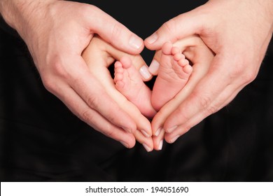 Newborn Baby Feet In Parents Hands