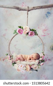 Newborn baby in floral dreamcatcher swing with peony, buttercup and roses flower