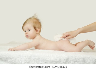 Newborn baby getting a diaper change: mom wiping baby's bottom with baby wipe