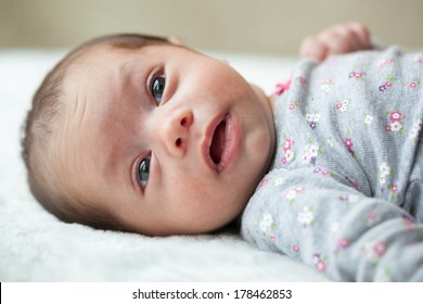 Newborn Baby Girl 6 Weeks Old With Eyes Open Laying On A Blanket