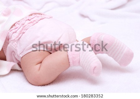 Newborn baby girl feet in pink socks