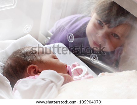 Similar – Baby girl reading book with family in the bed