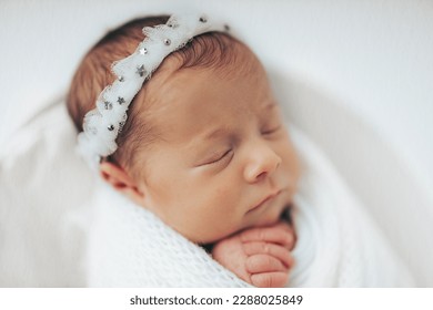 Newborn baby girl photographed in studio, on white background. Stylized and wrapped in bucket. Closeup portrait. - Powered by Shutterstock