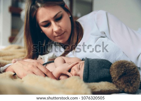 Similar – Newborn baby girl sleeping lying on blanket with her mother