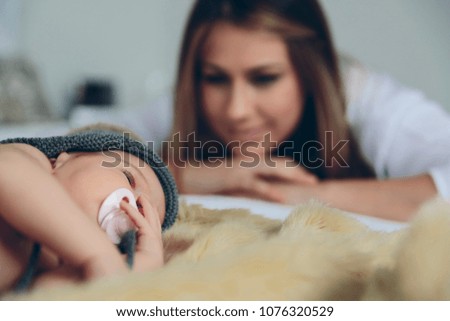 Similar – Newborn baby girl sleeping lying on blanket with her mother