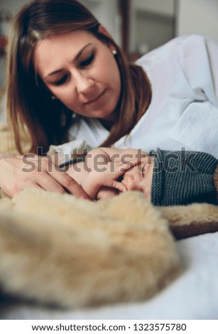 Newborn baby girl sleeping lying on blanket with her mother