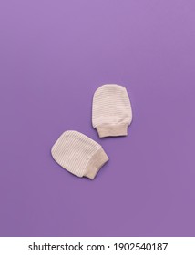 Newborn Baby Gloves, Flat Lay And Top View On Purple Background