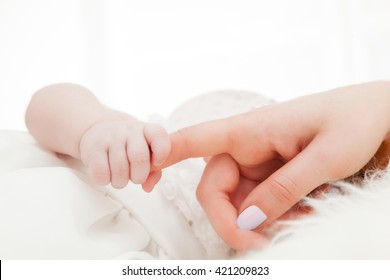 Newborn Baby Grasping Her Mother's Finger. Concept Of Child Care, Feeling Safe, Parent Love.