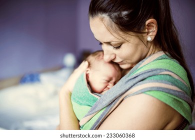 Newborn Baby Hold By Mother In The Baby Wrap Carrier.