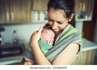 Newborn Baby Hold By Mother In The Baby Wrap Carrier.