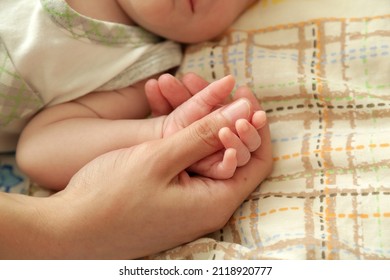 Newborn baby holding mother’s hand