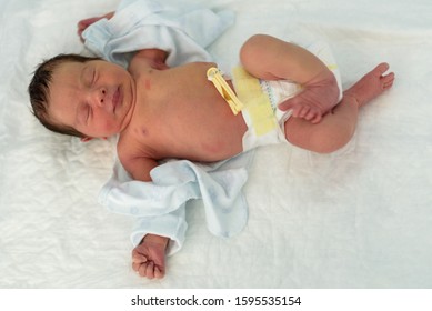 newborn baby in a hospital crib with a baby blanket 