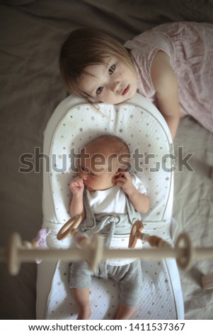 Similar – Image, Stock Photo Happy little girl holding doll and cookie while woman playing with a boy over the bed. Weekend family leisure time concept.