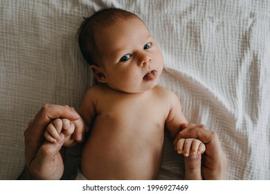 Newborn Baby Looking At Camera With Her Tongue Out.