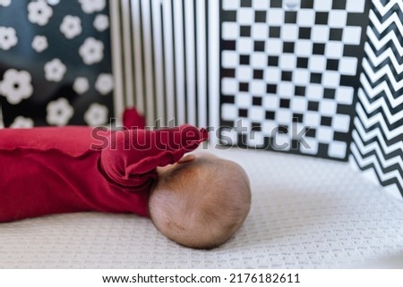 A newborn baby looks at contrast black and white pictures for the development of vision