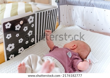 A newborn baby looks at contrast black and white pictures for the development of vision