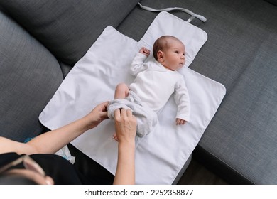 Newborn baby lying on changing table while being diapered - Powered by Shutterstock