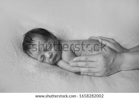 Similar – Newborn baby girl sleeping lying on blanket on bed