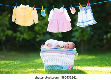 Newborn Baby On A Pile Of Clean Dry Towels. New Born Child After Bath In A Towel. Family Washing Clothes. Kids Wear Hanging On A Line Outdoors In Summer Garden. Infant Apparel, Textile For Children. 