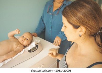 Newborn baby on weight scale close up