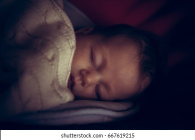 Newborn Baby Peaceful Sleeping In Dark Room With Low Natural Light Covered With Comfortable Blanket Symbolize Peace And Tranquility