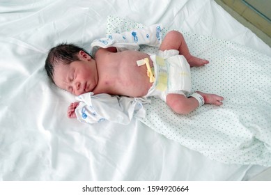 newborn baby resting in hospital crib 