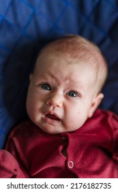 A Newborn Baby With A Scared Face Is Crying